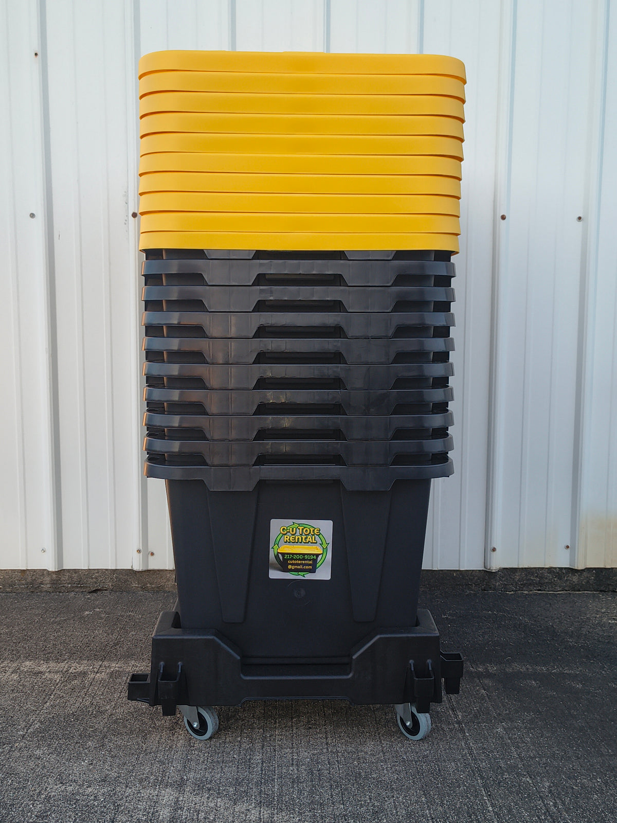 Stack of black totes with yellow lids on dolly